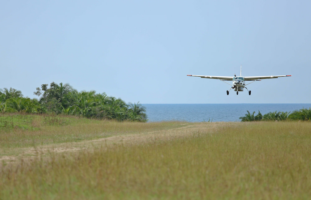 A small plane lines up its landing onto the grass airstrip of Rubondo Island.