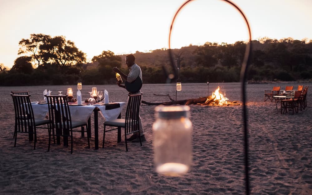 Guests at Kwihala Camp can enjoy sundowner drinks and candle-lit dinners in the dry Mwagusi riverbed.