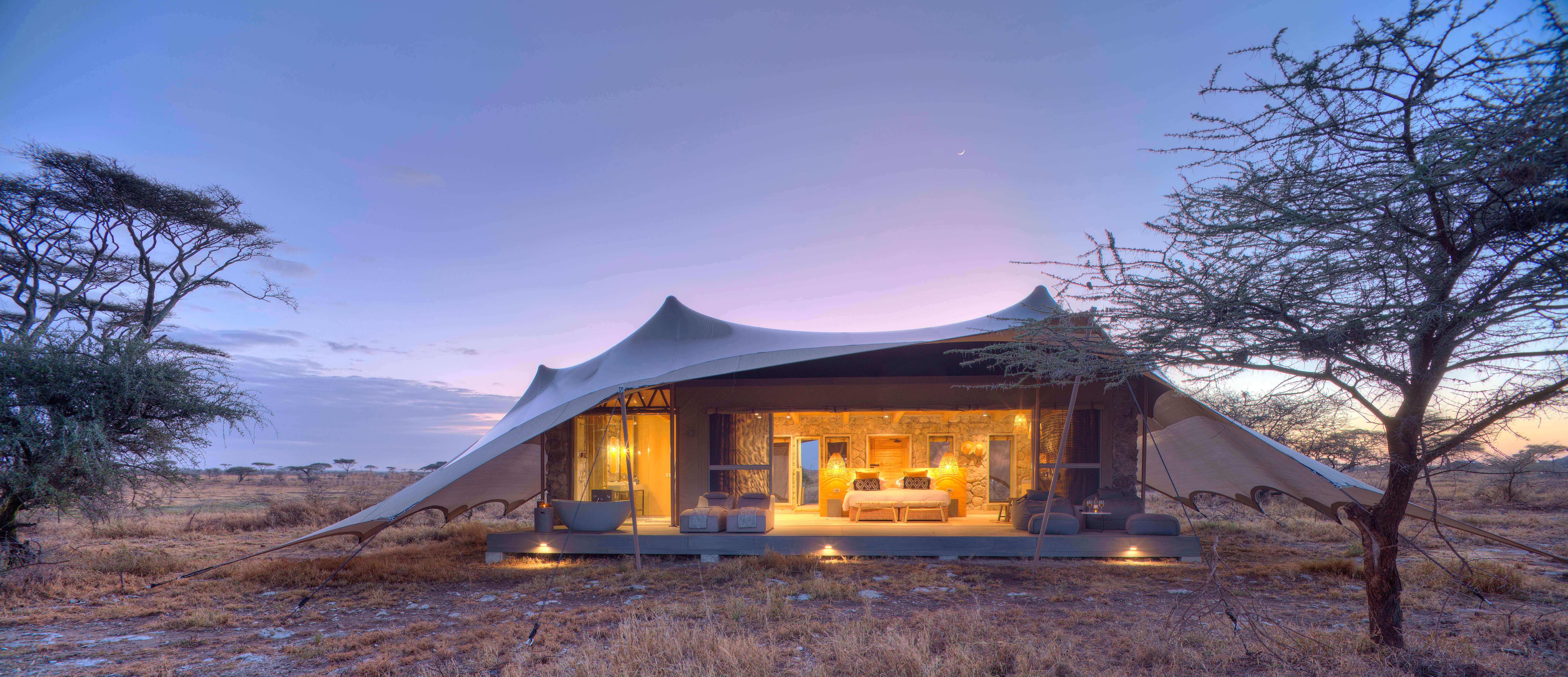 Namiri Plains tent at dawn - purple and blue hues with the bedroom lights sparkling