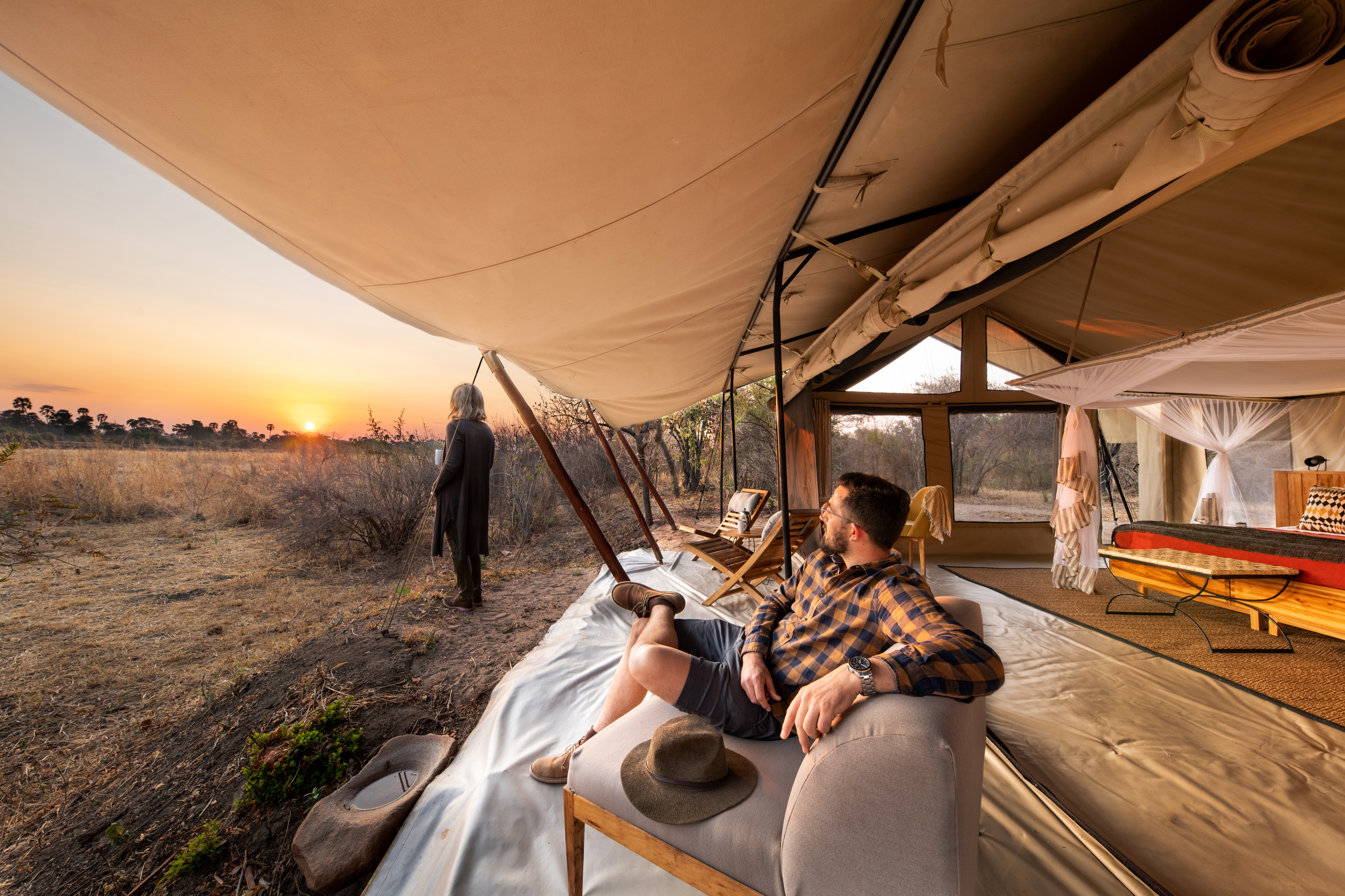 Guests in Kwihala Camp watch the sun set over the expanse of Ruaha National Park.