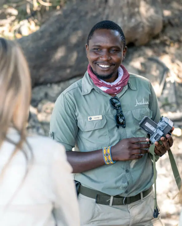 A smiling guide tells guests about camera traps and their uses in conservation