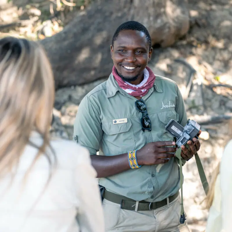 A smiling guide tells guests about camera traps and their uses in conservation