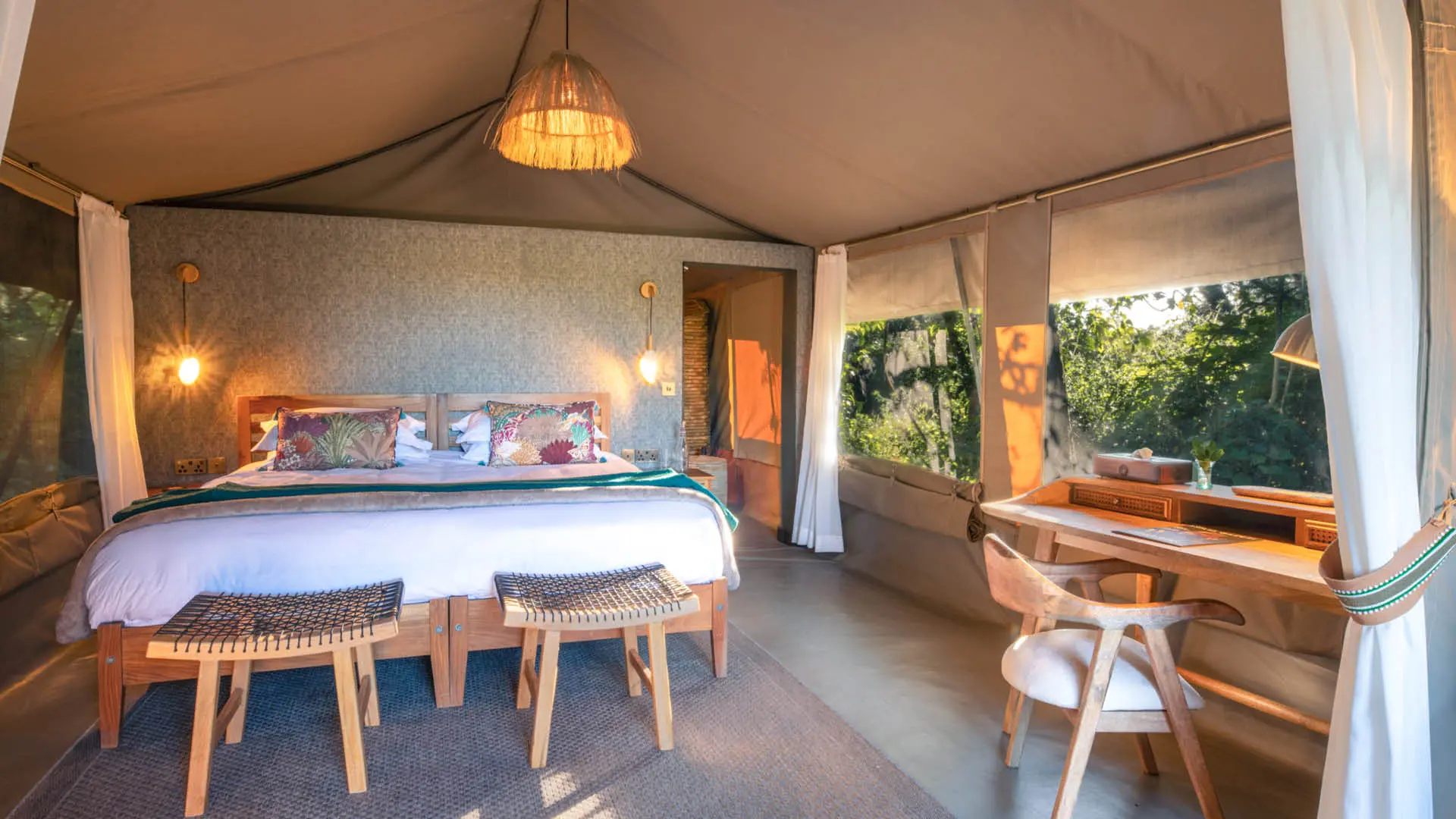 An internal view of a stylish suite at Rekero with a large bed and writing desk