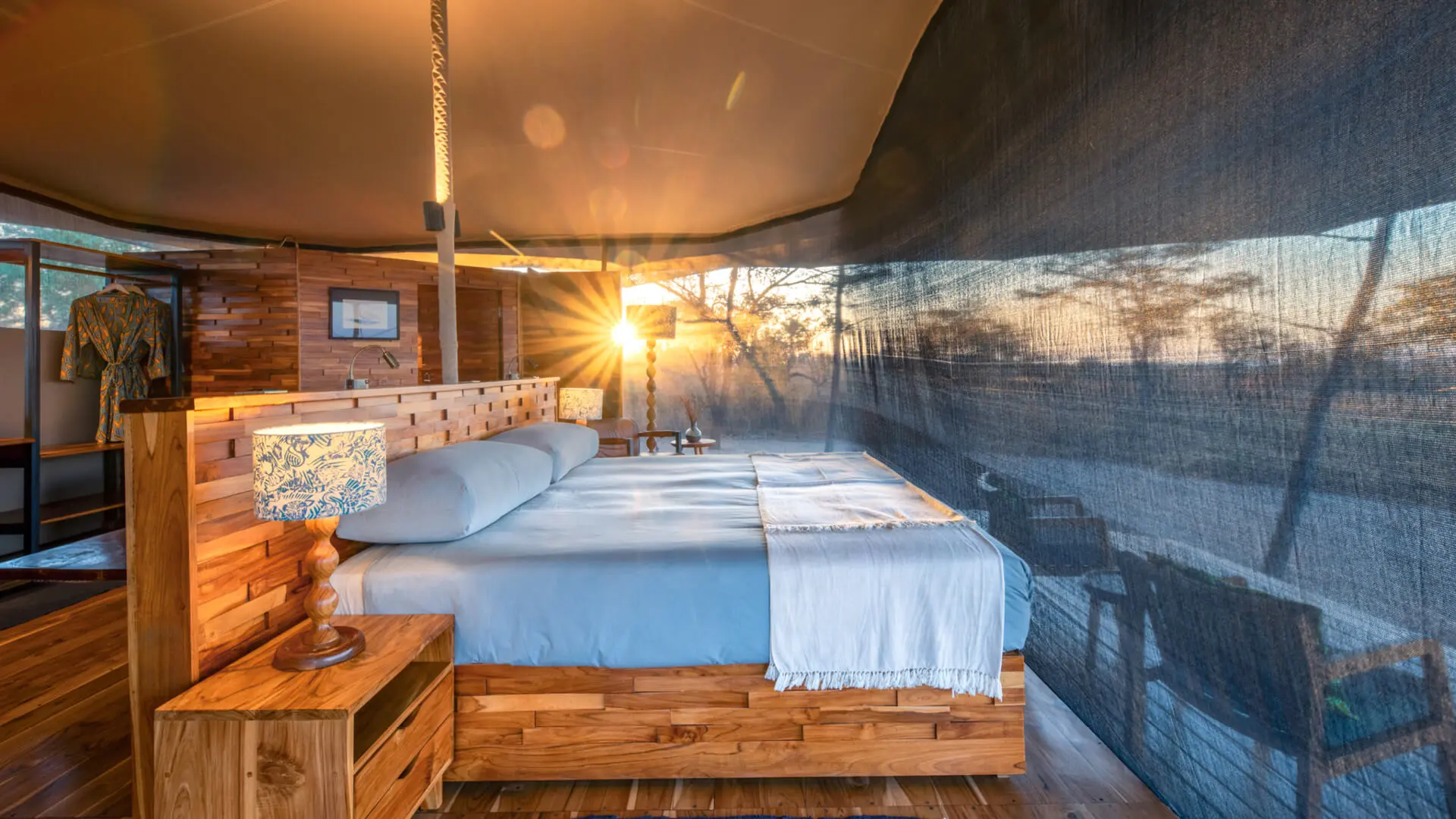 A tent interior showing a double bed and the view through the net sides