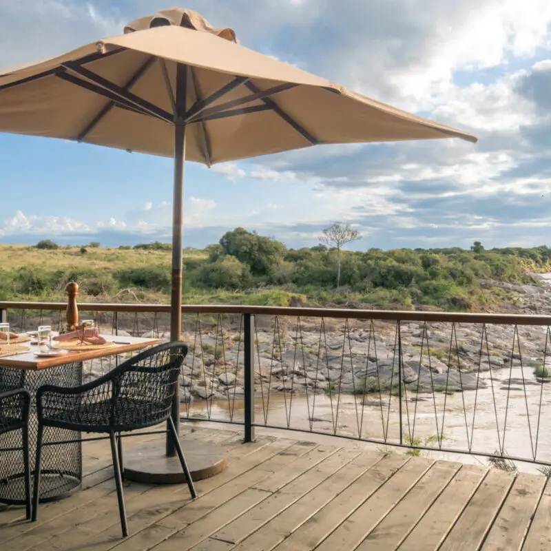 A table is set on the deck with a view of the river