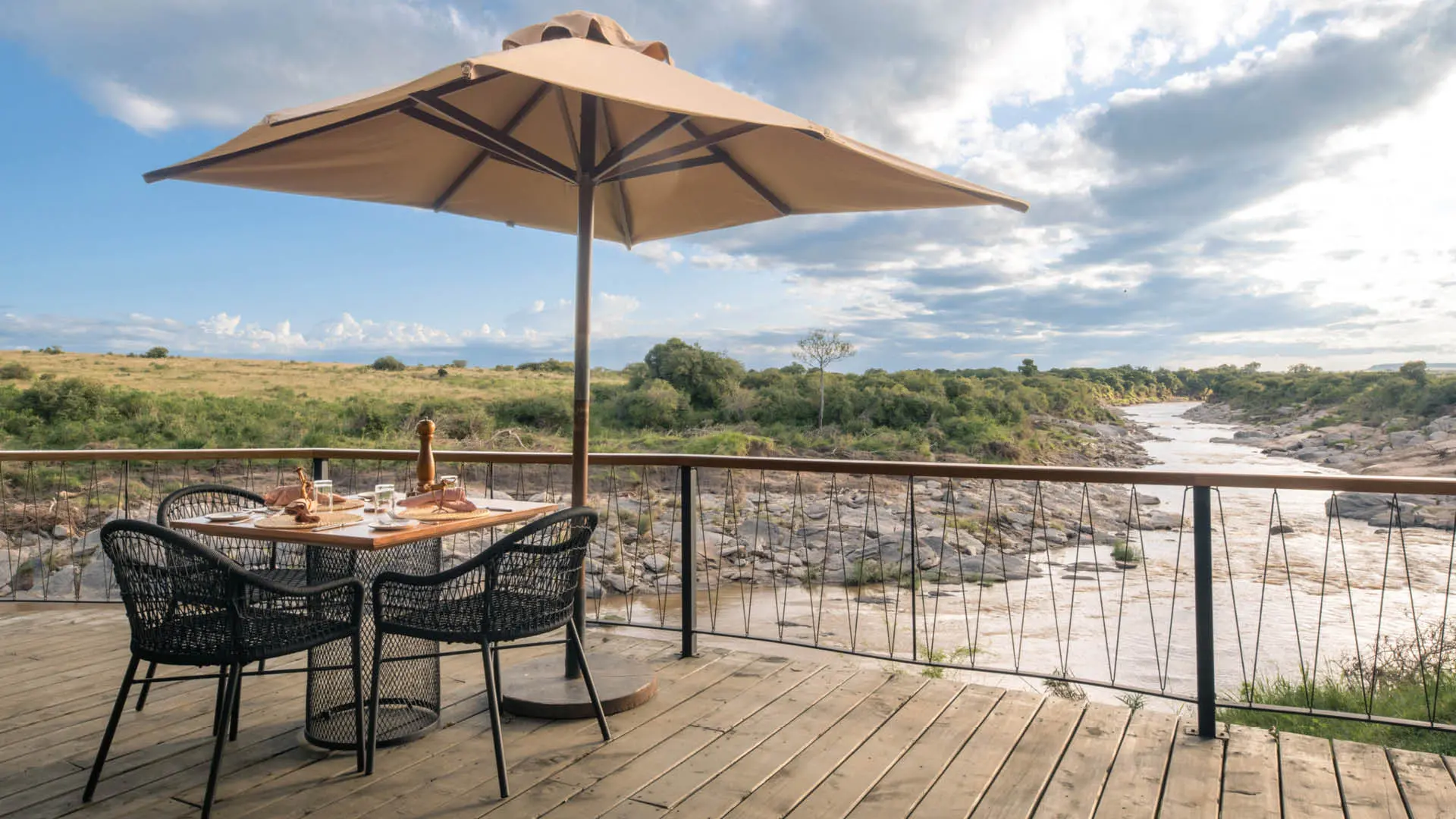 A table is set on the deck with a view of the river