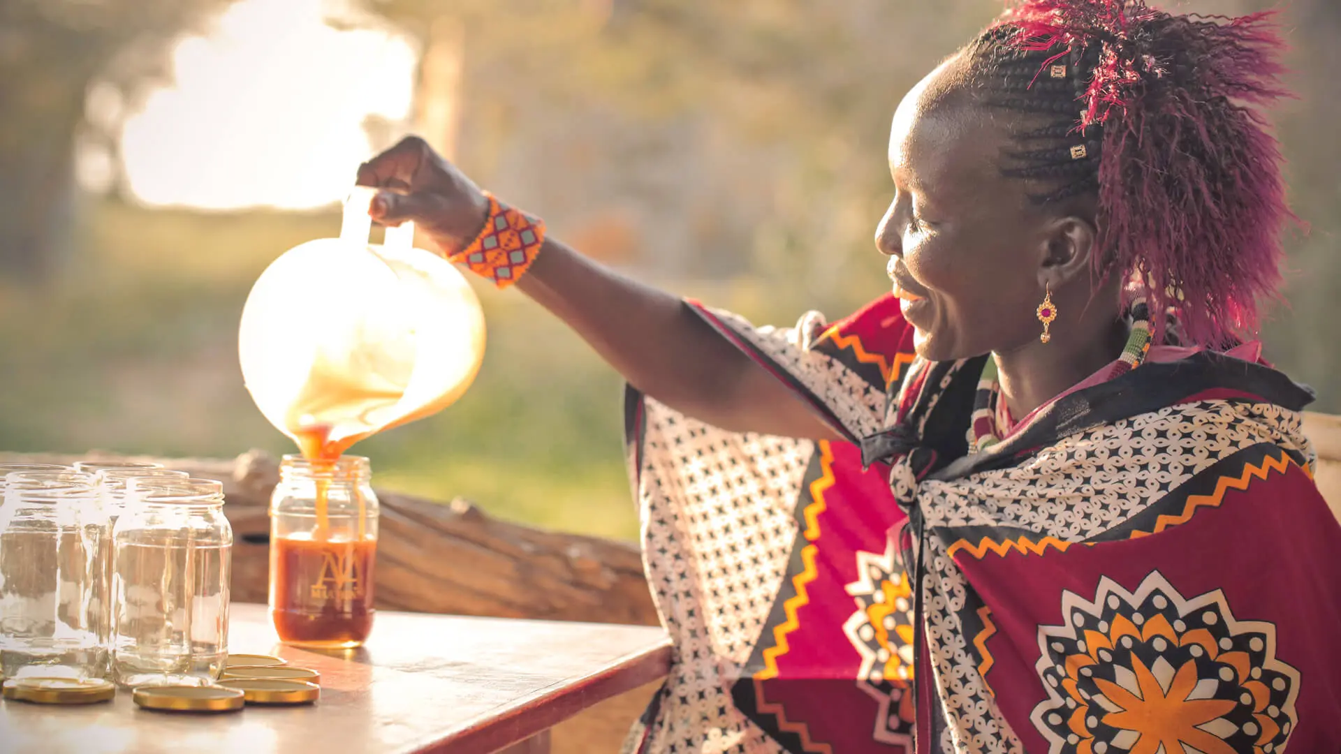 A Maasai women pours honey into jars. An initiative of the Maa Trust in Kenya.
