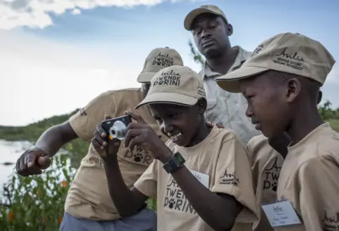 Children on the Twende Porini program experiment with a digital camera, Kenya.