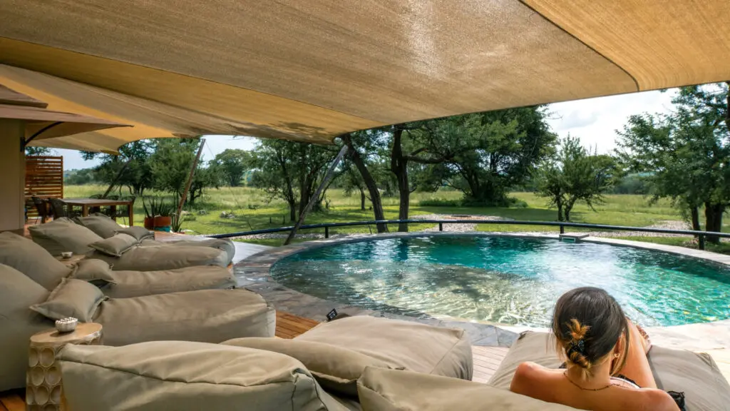A female guest relaxes beside the private pool on safari