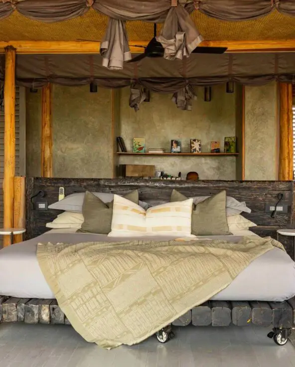 Jabali Private House - spacious safari lodge double bedroom with a four-poster bed draped in soft linens, wooden pillars, open shutters, and natural light flowing through the room.