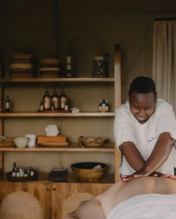 A masseuse performing a massage treatment for a guest staying at Naboisho Camp in the Mara Naboisho Conservancy, Kenya.