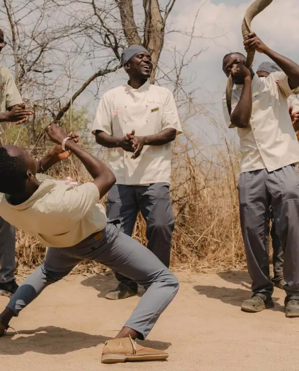 Asilia staff clapping, dancing and singing together to welcome guests
