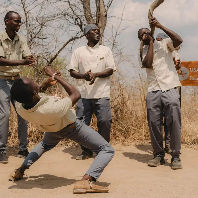 Asilia staff clapping, dancing and singing together to welcome guests