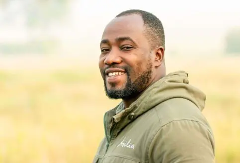 male safari guide smiling at the camera at ubuntu migration camp, tanzania, east africa