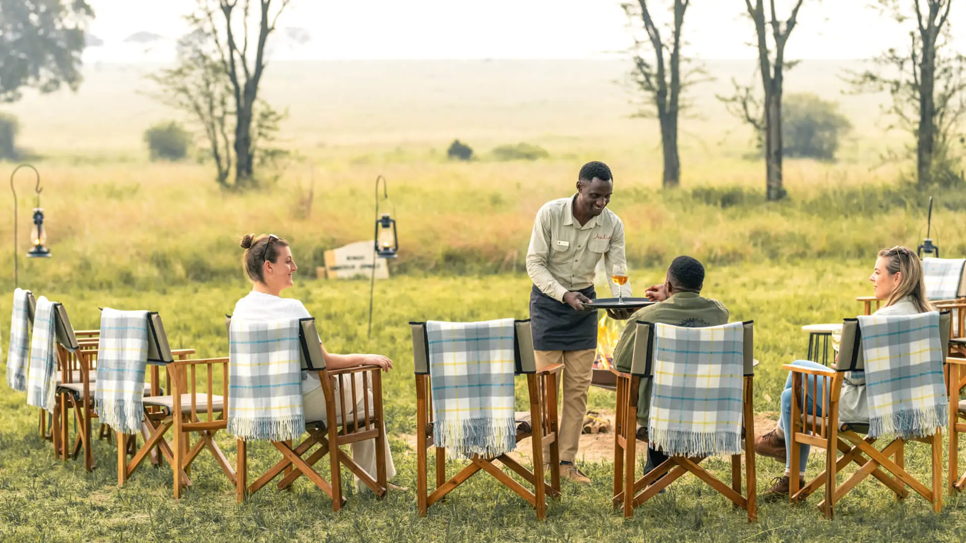 Guests receive their sundowner drinks from a smiling waiter
