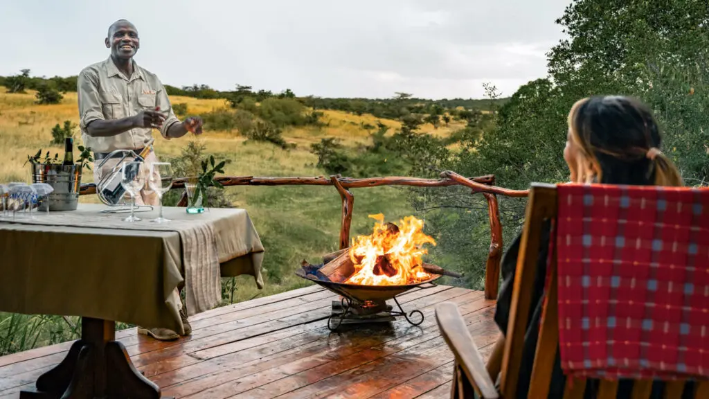 Sundowners around the campfire on outside deck, mara naboisho conservancy, kenya