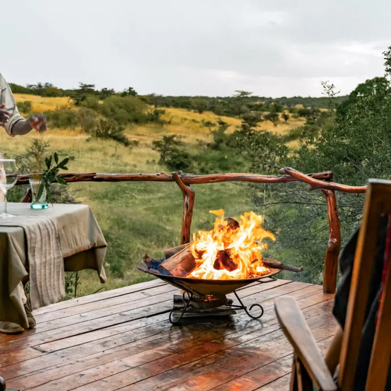 Sundowners around the campfire on outside deck, mara naboisho conservancy, kenya