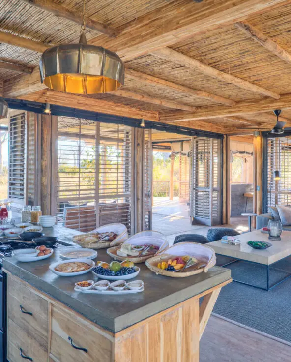 Jabali Private House, Ruaha National Park, kitchen with breakfast setup next to the lounge area and leading on to the deck with shutter doors open