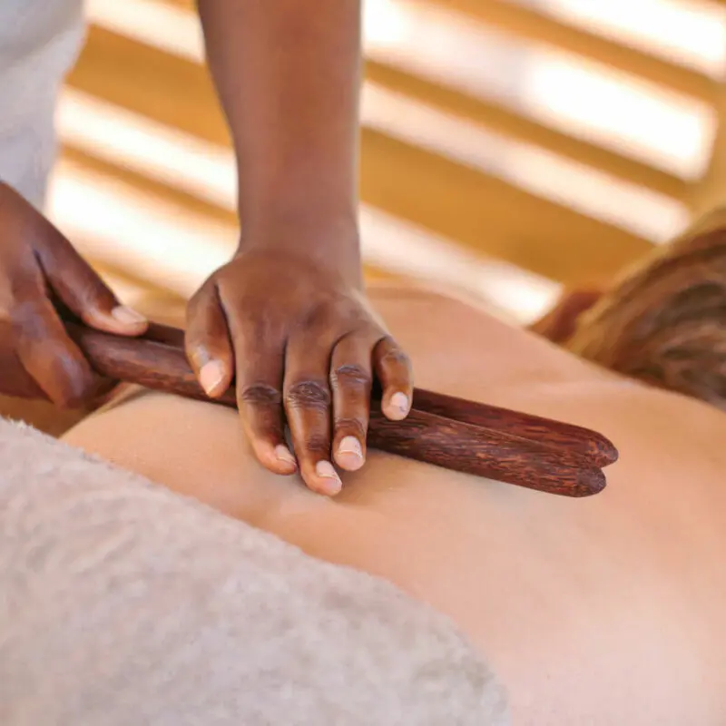 Jabali Private House, Ruaha National Park, Spa treatment for guest, therapist using two sticks across guest's back with her hands