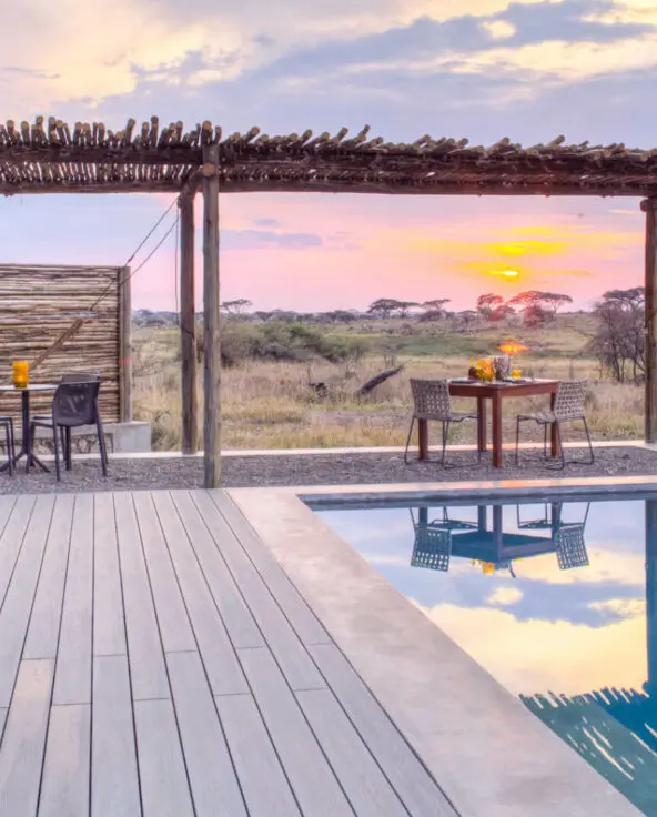 Namiri Plains, Serengeti National Park, pool at sunset, loungers on the deck, table and chairs, hammock