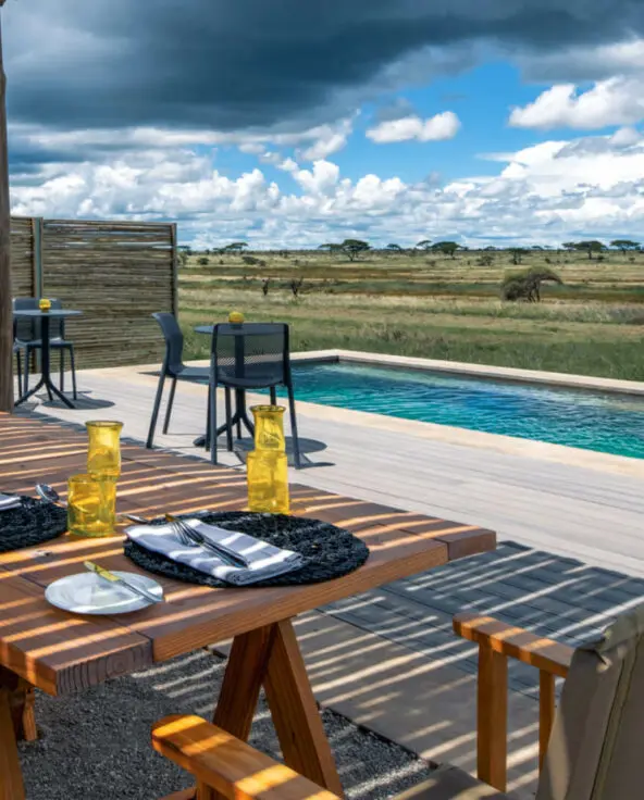 Namiri Plains Retreat, Serengeti National Park, lunch setup at the pool, table and chairs on the deck, placemats and shanga glasses on the table