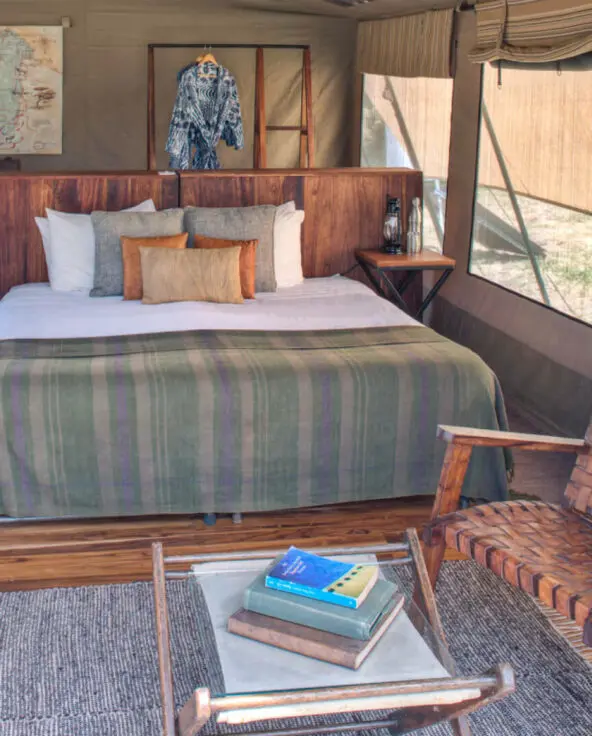 Asilia olakira migration Camp, inside guest tent, bed and chairs, Serengeti National Park, Tanzania