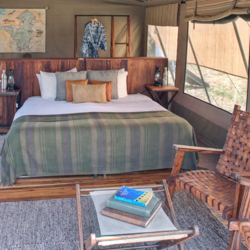 Asilia olakira migration Camp, inside guest tent, bed and chairs, Serengeti National Park, Tanzania