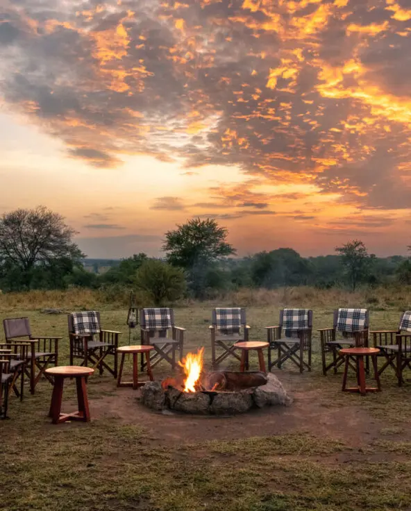 Sayari Camp, Northern Serengeti, chairs around firepit at dusk, sun setting