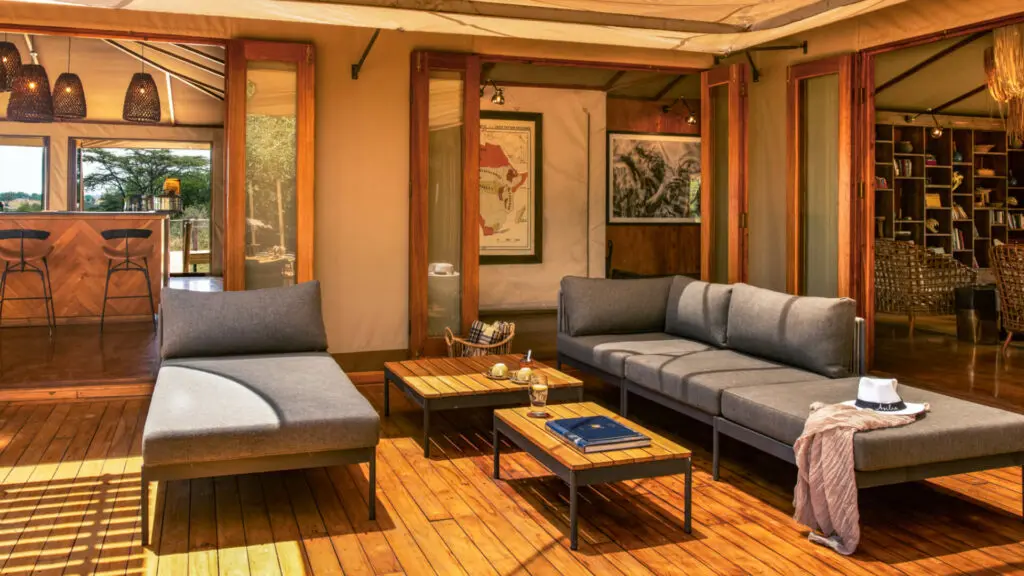 Sayari Camp, Northern Serengeti, loungers with table on deck, open doors leading into public area