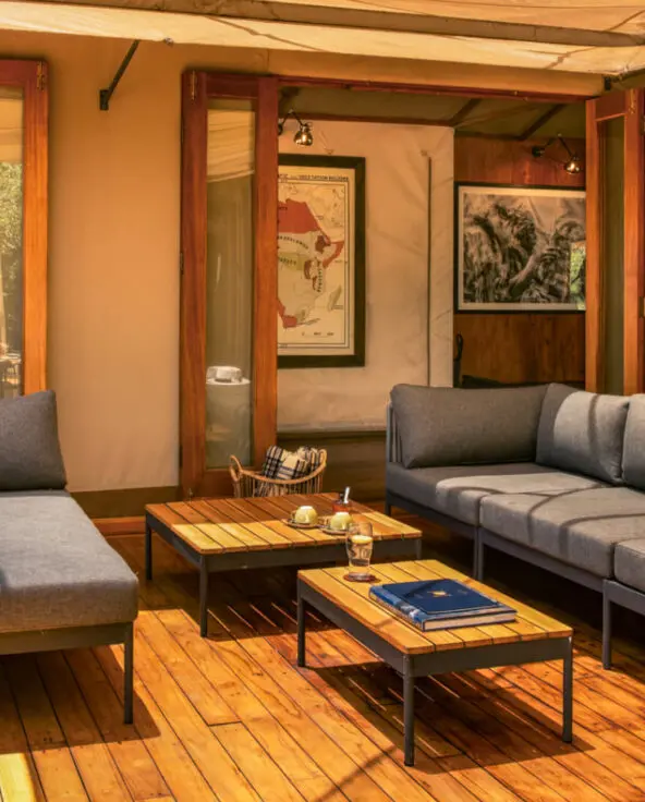 Sayari Camp, Northern Serengeti, loungers with table on deck, open doors leading into public area