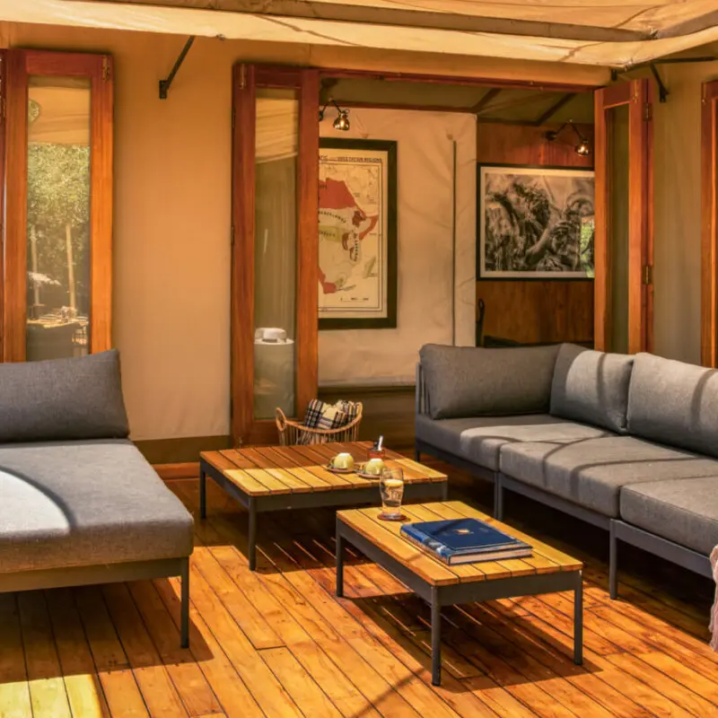 Sayari Camp, Northern Serengeti, loungers with table on deck, open doors leading into public area