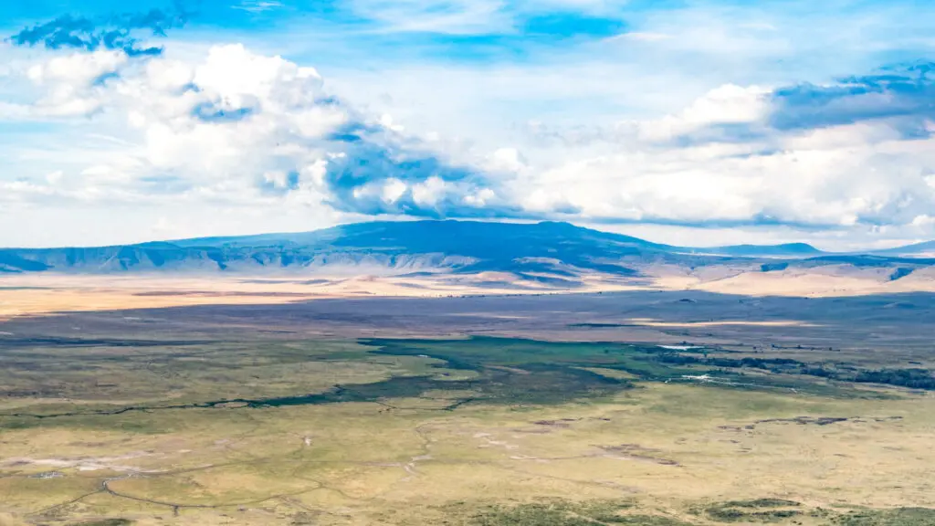 landscape of grass, mountain and clouds, ubuntu migration camp, Serengeti National Park, Tanzania