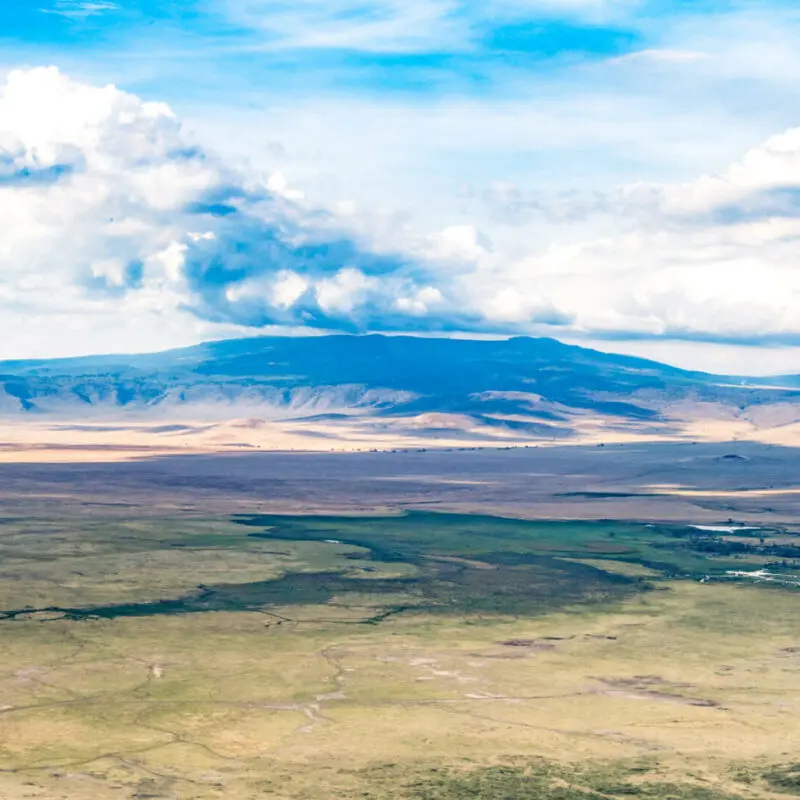 landscape of grass, mountain and clouds, ubuntu migration camp, Serengeti National Park, Tanzania