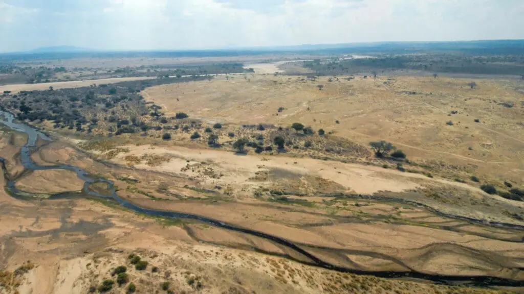 Usangu Expedition Camp, Ruaha National Park, landscape, river flowing, trees and bushes surrounding, dry land