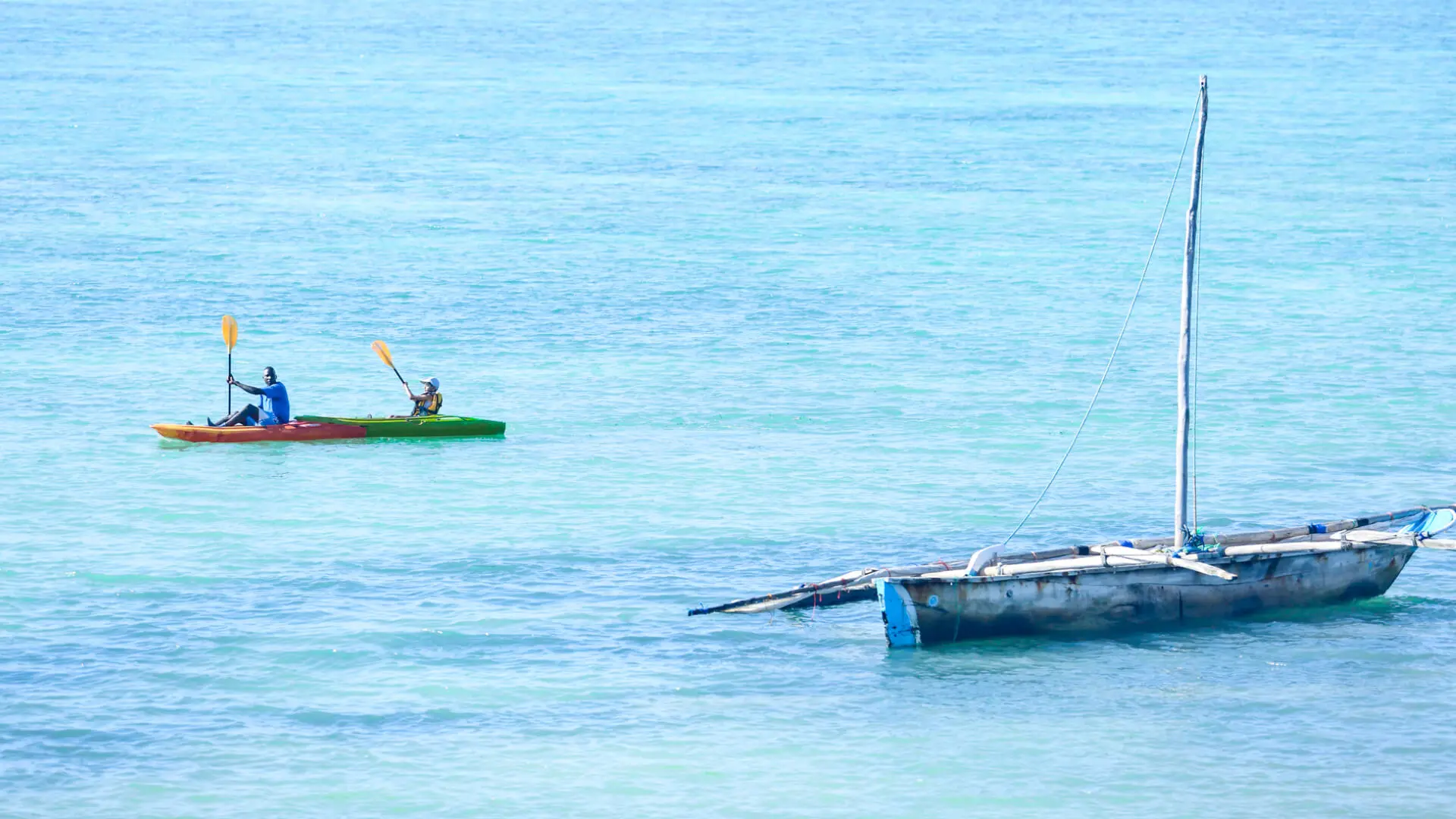 Two people in a canoe on blue waters in zanzibar