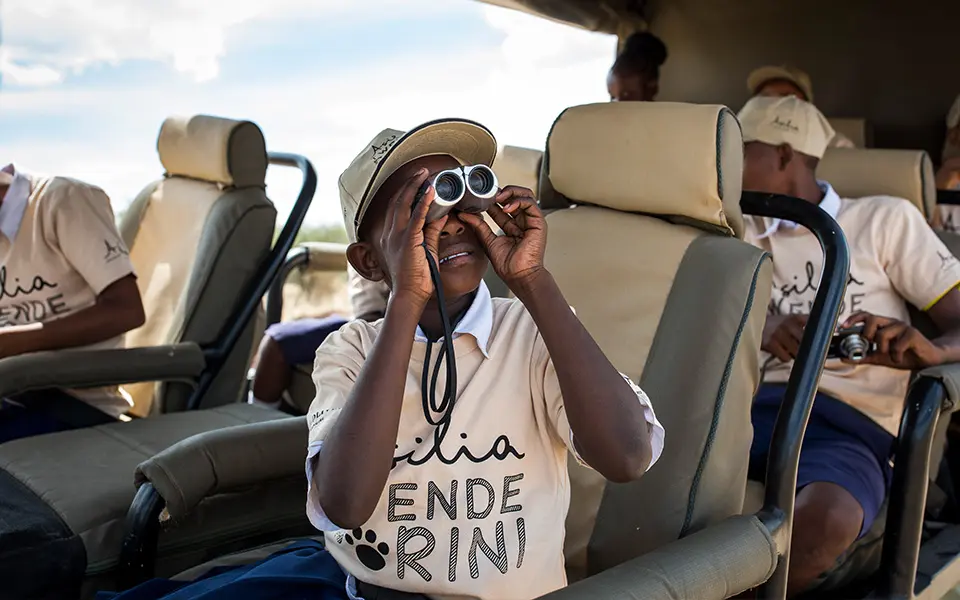 Twende Porini team member looking through binoculars