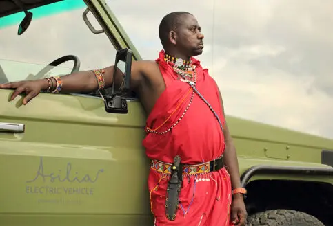 Guide stands alongside an Asilia Electric Safari Vehicle | Asilia Africa