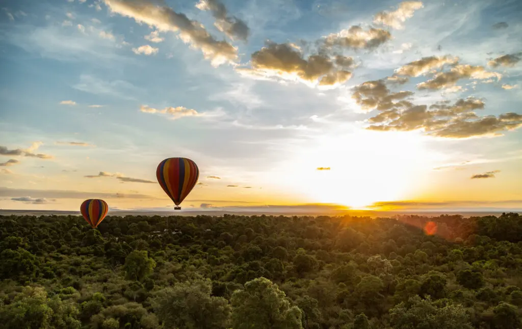 Une montgolfière survole la Mara au coucher du soleil
