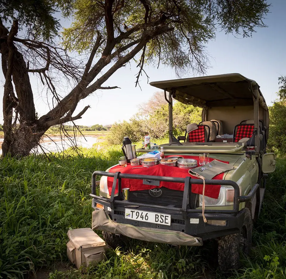 Brunch is served on th bonnet of a safari vehicle | Asilia Africa