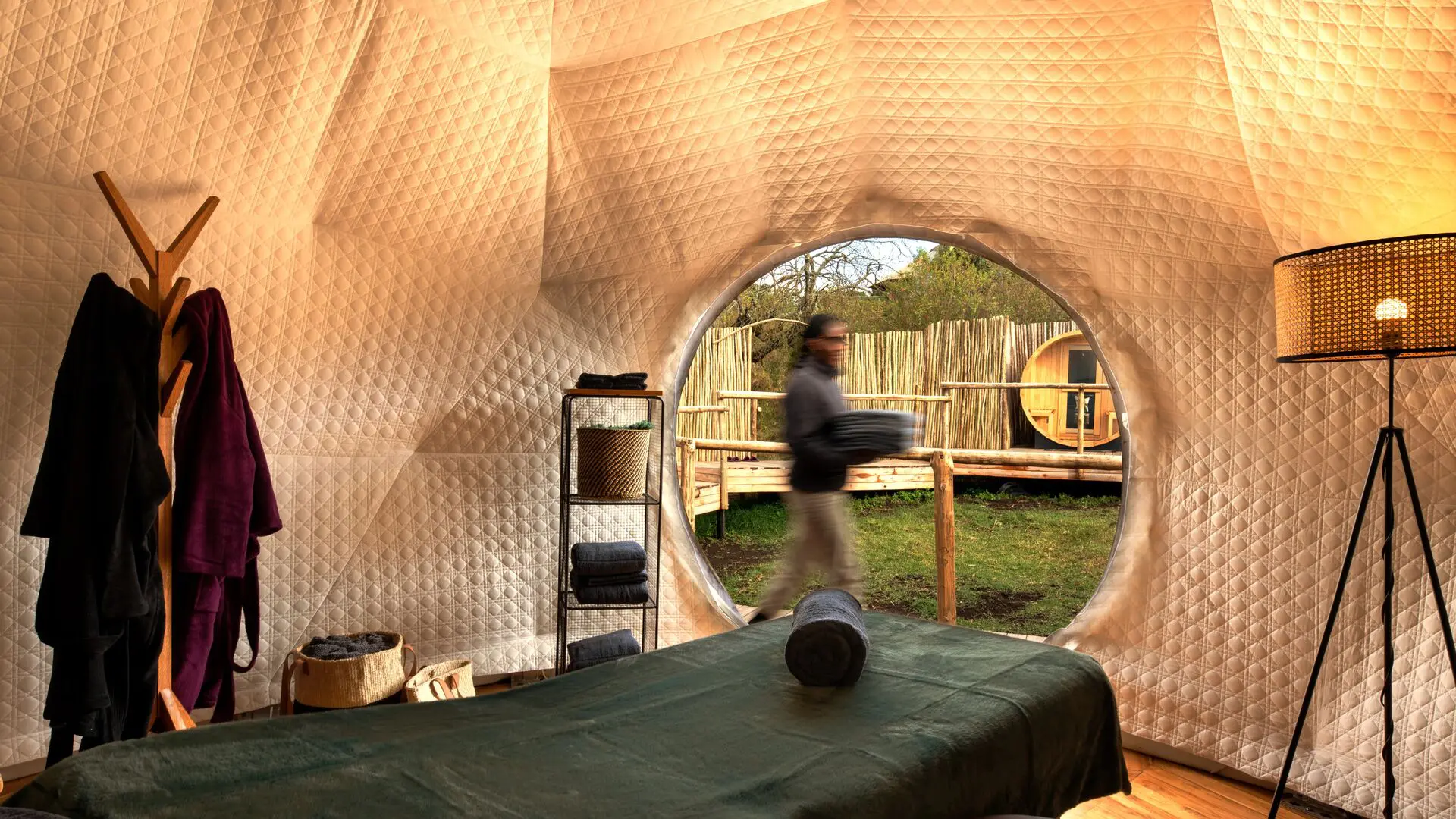 Spa treatment room inside a geodesic dome at The Highlands in Tanzania, with a massage bed and views outside.