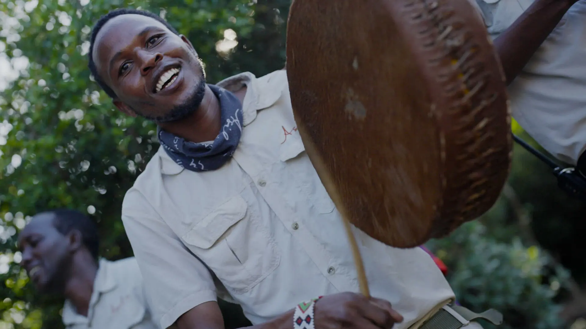 Group of Asilia staff playing music and dancing with smiles