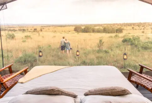 Serengeti National Park, lanterns outside star gazing tent with couple in the distance