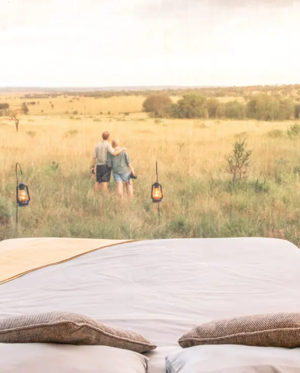 Serengeti National Park, lanterns outside star gazing tent with couple in the distance