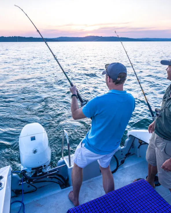Lake Victoria, guest standing in the boat catching a fish