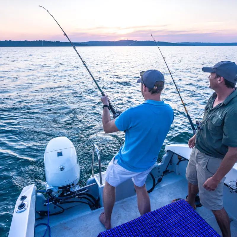 Lake Victoria, guest standing in the boat catching a fish
