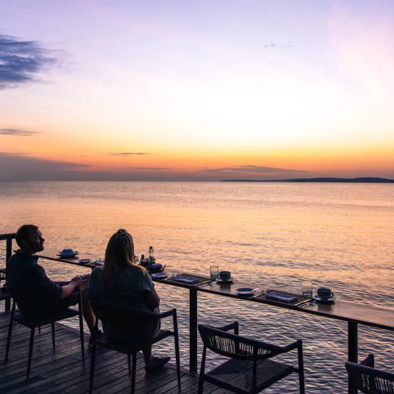 Sunset view over Lake Victoria, couple enjoying drinks