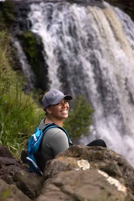 A guest enjoying the sights and sounds of the waterfall during the Olmoti Crater hike, The Highlands.
