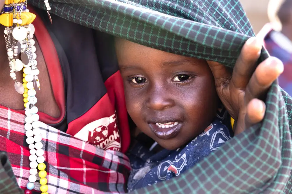 A Maasai child peeks out from beneath a blanket, Ngorongoro Conservation Area.