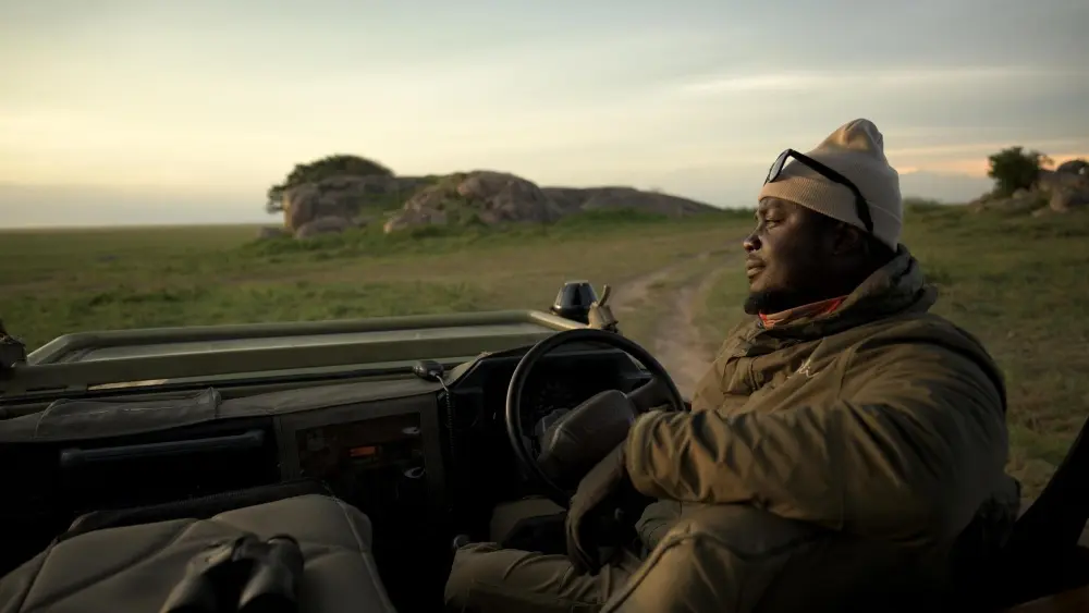 Anderson looking content in his vehicle at sunrise on the Namiri Plains.