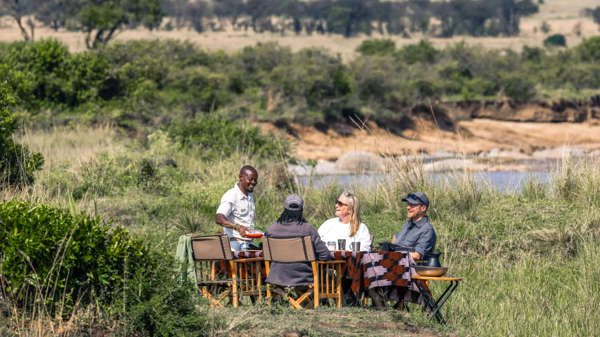 Guests being served lunch on the banks of the river in Serengeti National Park